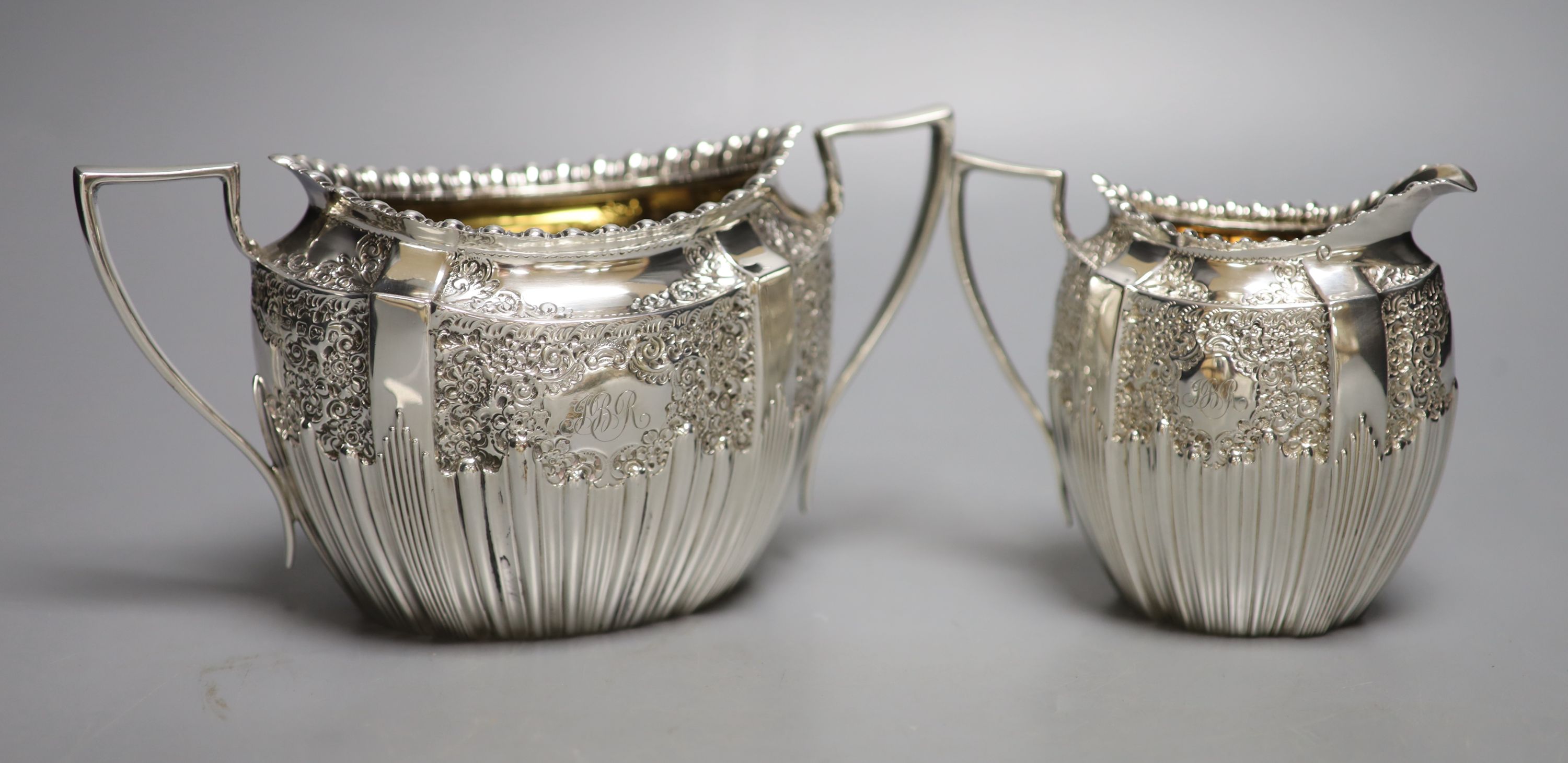 A late Victorian embossed silver sugar bowl and cream jug, James Dixon & Sons, Sheffield, 1896/7,